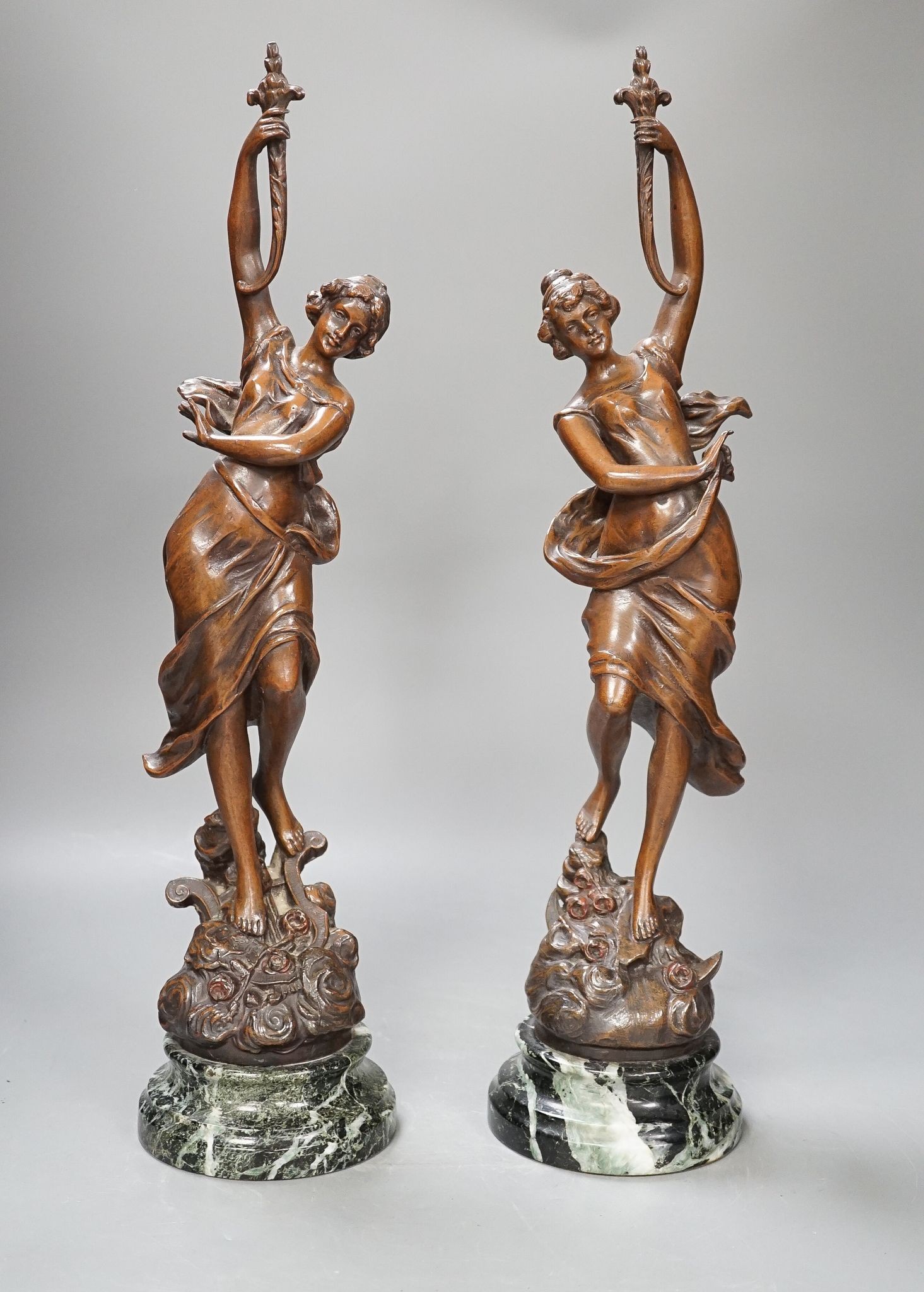 A pair of bronze female dancers, on marble plinths, 47cm